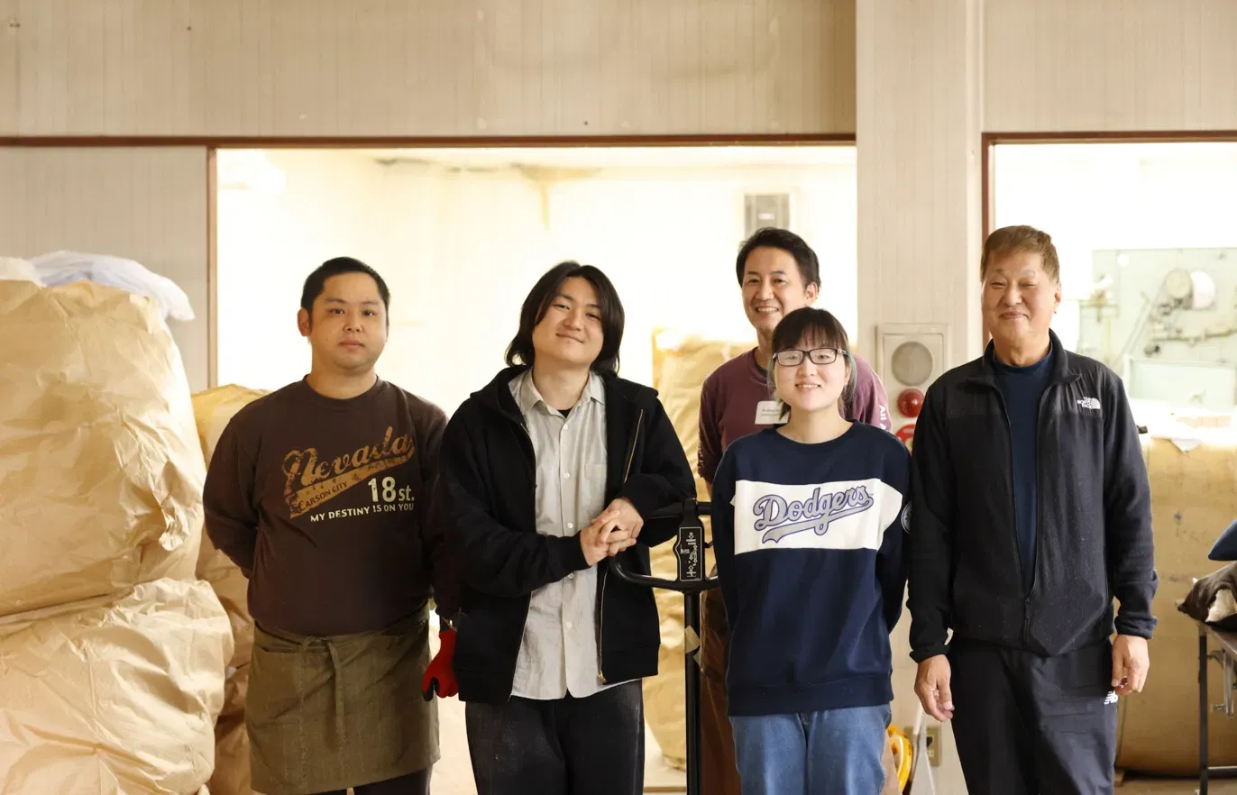 SUSTEB FACTORY 都留のチームメンバーが工場内で並んでいる